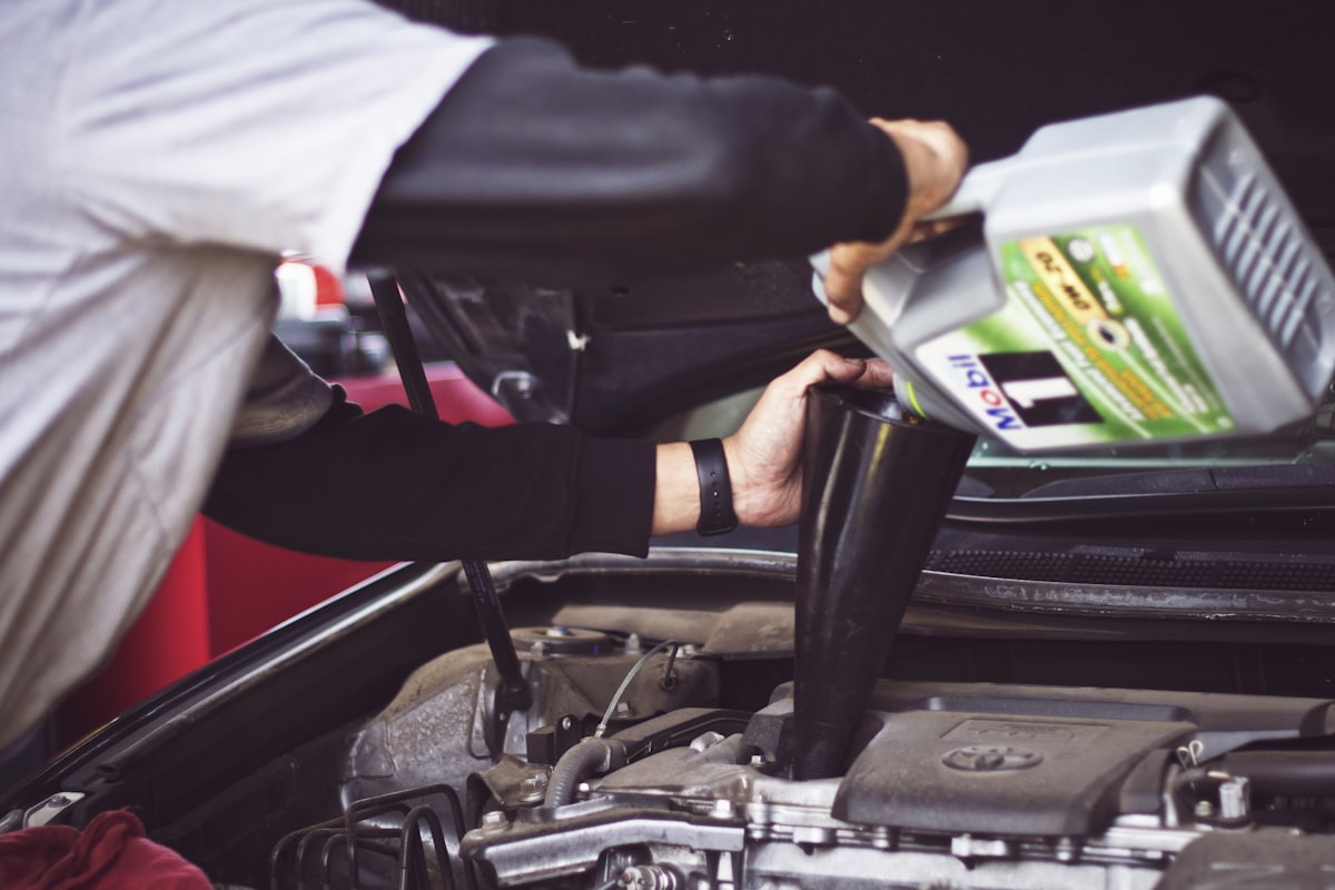 Mechanic pouring fresh oil into a car engine